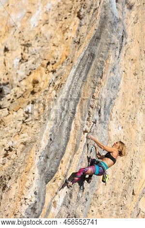 The Girl Climbs The Rock. The Climber Trains On Natural Terrain. Extreme Sport. Outdoor Activities. 