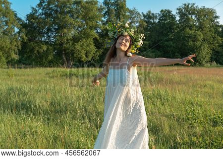 Woman Dance Ecstatic Dance In Field. Woman In Flower Wreath. Summer Solstice Day