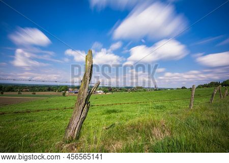 Green Field With Wooden Fence And Landscape