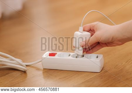Woman Pluging The Wire Into White Extension Cord. Close Up Of Female Hand Put Cabel