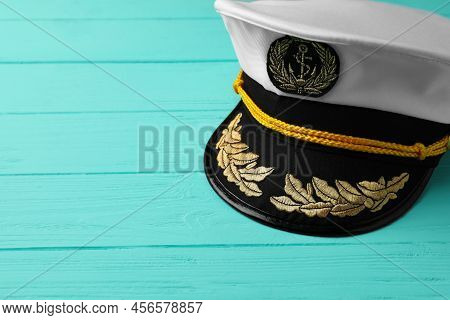 Peaked Cap With Accessories On Turquoise Wooden Background, Space For Text