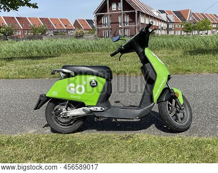 Almere, The Netherlands - June 17, 2022: Green Go Sharing Electric Scooter Standing In By The Side O