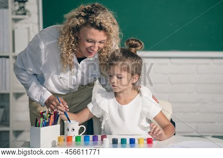 Kid Drawing With Teacher. Children From Elementary School Study At Draw Lesson. Pupil With Teacher P