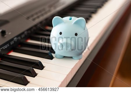 Music And Saving Concept With Piano And Piggy Bank
