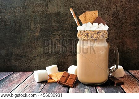 Smores Drink In A Mason Jar Glass With Ingredients Against A Dark Background. Graham Crackers, Choco