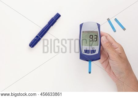 Glucometer In Hand With 9.3 Mmol Per Liter Glycemic Index On Display