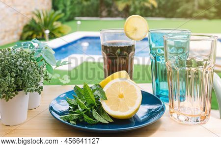 Still Life Of Glasses With Mint And Lemon Soda, On A Wooden Table Outside. Summer Scene, Drinks To C