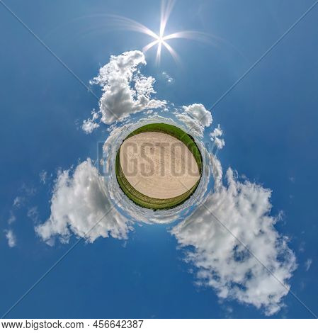 Tiny Planet In Blue Sky With Beautiful Clouds With Transformation Of Spherical Panorama 360 Degrees.