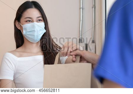 Young Asian Woman, Customer Wearing Face Mask Protect To Pandemic Of Covid And Received Bag,cardboar