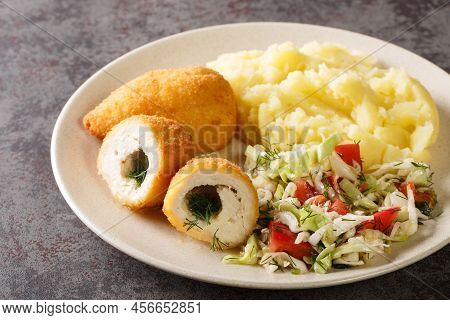 Chicken Kiev Cutlets Served With Salad And Mashed Potatoes Closeup In The Plate On The Table. Horizo