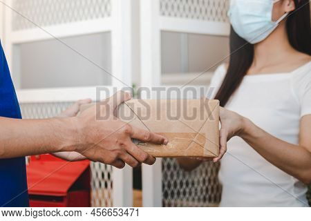 Young Asian Woman, Client Accepting A Delivery Of Cardboard Box, Parcel From Delivery, Postman, Wear