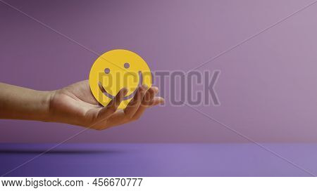 Positive Mind, Enjoying Life Concept. Hand Holding A Smiling Face Paper. Sign Of Mental Health, Well