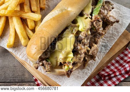 Philly Cheesesteak Sandwich With Beef, Cheese,green Pepers And Caramelized Onion On Wooden Table.tra
