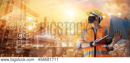Double Exposure. Construction Worker With Mask And Laptop Computer In Hand With Icon Construction On