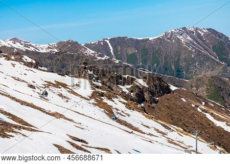Rocky Snow-capped Mountains Under The Sun And Blue Sky