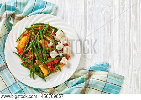 Fasolakia Lathera, Green Beans, Onion And Potatoes Stewed In Tomato, Herbs And Olive Oil On White Pl