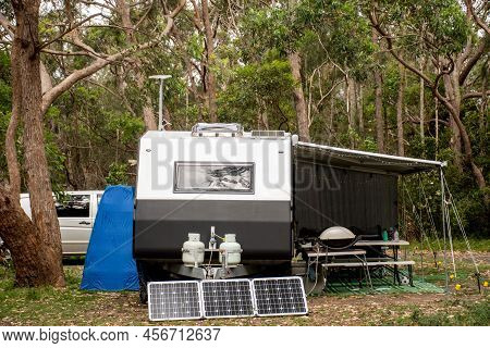 Rv Caravan Camper On A Campsite In The Bush Forest Nature. Awning, Portable Toilet, Solar Panels, Bb
