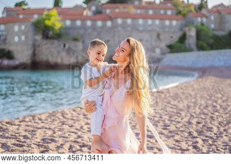 Mother And Son Tourists On Background Of Beautiful View St. Stephen Island, Sveti Stefan On The Budv