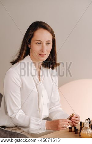 The Aromatherapist Girl Is Sitting In Her Office. There Are Essential Oils On The Table