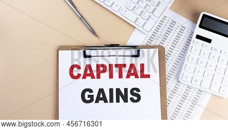 Clipboard With White Blank Paper Text Capital Gains , Keyboard Calculator And Chart, Business Concep