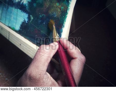 Artists Brush Or Painting Brush With Painting In Blurred Background.