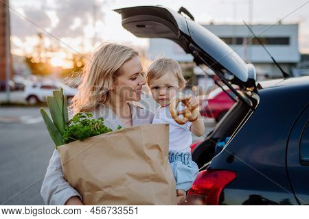 Young Mother With Little Daughter After Shopping Holding Zero Waste Shopping Bags With Grocery Near 