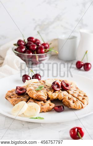 Appetizing Croffles With Cherries And Bananas On A Plate On The Table. Street Food. Homemade Breakfa