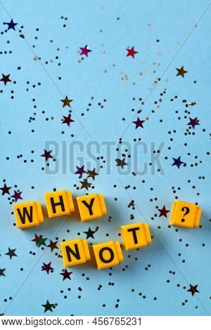 Vertical Shot Of Yellow Cubes With Why Not Question Inscription. Confetti On Blue Background. Top Vi