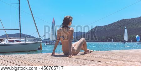 Girl In A Bikini Sits On A Pier Near Lake Abrau-dyurso.