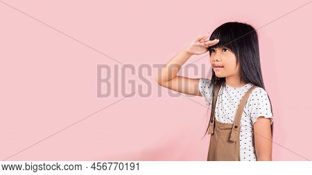Searching Concept. Asian Little Kid 10 Years Old Looking Far Away With Hand Over Head At Studio Shot