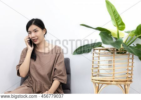 Young Asian woman happily using her mobile phone to vdo call  or talking with her friends, Entertain