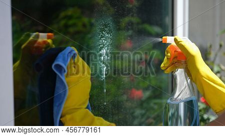 Close-up Of Woman Using Detergent And Rag For Cleaning Window. House Cleaning, Housekeeping And Spri