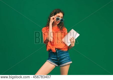 Portrait Of Young Girl, Student In Casual Outfit And Sunglasses With Tablet Posing Isolated Over Gre