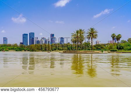 Tel-aviv, Israel - June 17, 2022: View Of The Park Lake, Palm Trees And Office Buildings In The Back