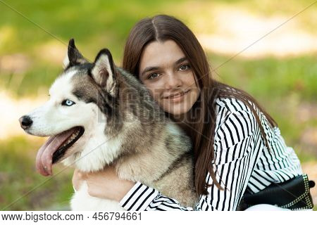 The Girl Hugs Her Furry Friend. The Teenager Poses For A Photo. The Dog And It's Owner.