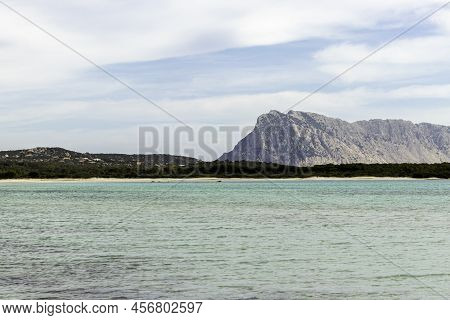 Lu Impostu Beach Shore With Mountain The Background And No People, San Teodoro, Sardinia, Italy.