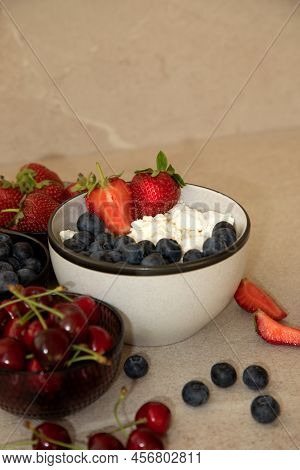 Curd With Fresh Blueberries And Strawberries In A Plate On A Beige Background. Healthy Breakfast, Fr