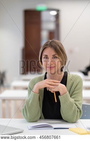 Returning To University As Mature Student. Happy Female Adult Learner Smiling At Camera While Studyi