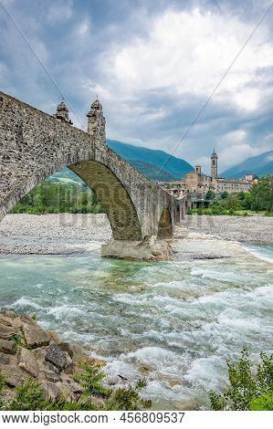 Bobbio, Italy , The Old Bridge (also Known As The Devil's Bridge) Over The Trebbia River, With The C