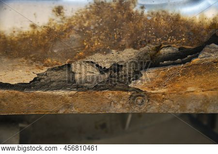 Deep Rust On The Body Of A Gray Old Car. Rust And Corrosion Hole On Old Worn Out Painted Metal Surfa