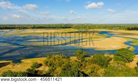 Lakes And Wetlands Among The Jungle Against The Backdrop Of Mountains And Blue Skies. Sri Lanka.