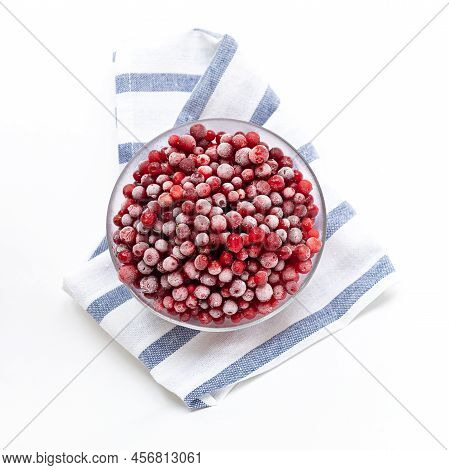 Frozen Forest Cowberry In Glass Bowl On Striped Napkin On White. Top View. Square Photo.