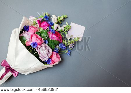 Fresh Summer Bouquet Of Roses Foxgloves Bachelor Buttons Flowers Wrapped In Paper And Arranged On Ba