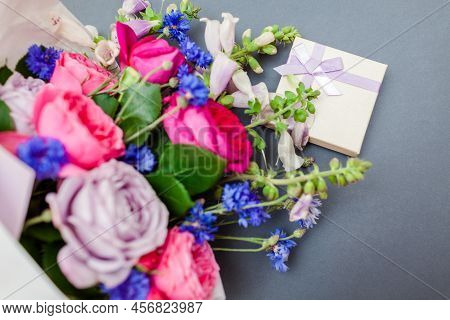 Close Up Of Summer Bouquet Of Roses Foxgloves Bachelor Buttons Flowers Wrapped In Paper And Arranged
