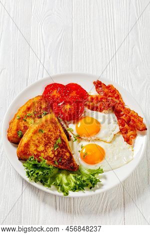 Irish Breakfast Of Potato Farls, Fried Eggs, Bacon Slices, Grilled Tomatoes And Fresh Lettuce On Whi