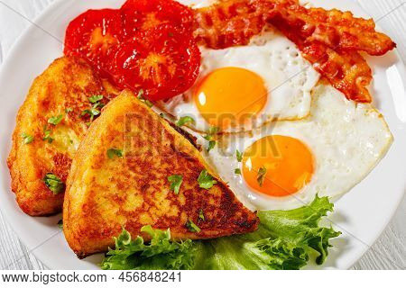 Fried Eggs, Rasher Or Bacon Slices, Potato Farls, Grilled Tomatoes And Fresh Lettuce On White Plate 