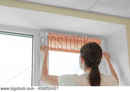 Installation Of Roller Blinds. Woman Specialist Installs Roller Blinds On The Window