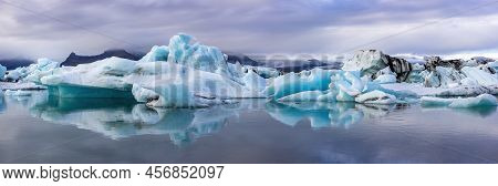 Wide Panorama Of The Jokulsarlon Glacial Lagoon, Southern Iceland. Mirror Reflection Of The Blue Ice