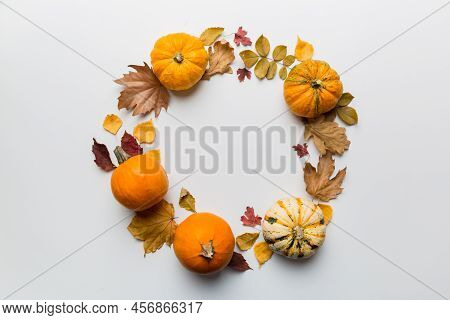Autumn Composition Pumpkins With Fall Leaves Over Coloredbackground. Top View With Copy Space.