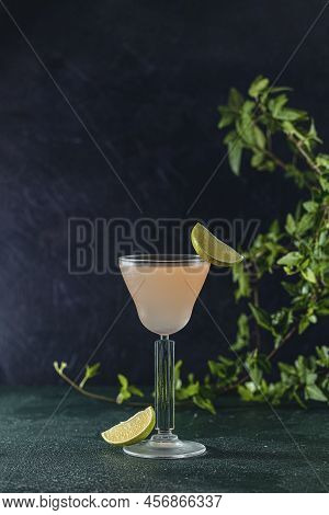 Glass Of Refreshing Pegu Club Cocktail Served On Dark Green Table Surface Surround Of Fresh Lime, Sh
